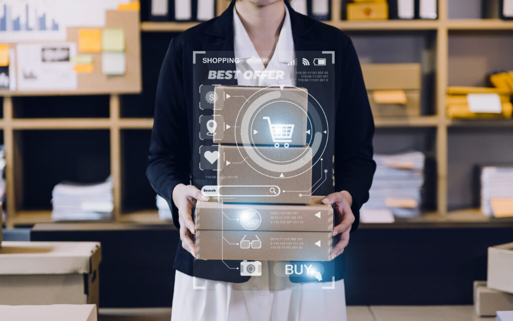 Una persona sosteniendo cajas de cartón con una superposición de gráficos digitales de seguimiento y un botón de "comprar", destacando los procesos de automatización retail en la gestión de inventarios y logística