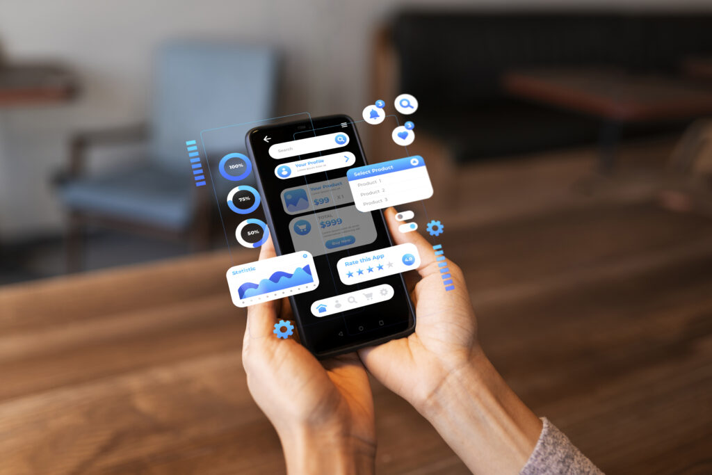 interfaz-analitica-agentes-de-ia-empresariales Manos sosteniendo un smartphone que muestra una interfaz digital avanzada con gráficos estadísticos, notificaciones y selectores de productos flotantes. La imagen representa el monitoreo de datos y la gestión de procesos a través de agentes de IA empresariales en dispositivos móviles dentro de una oficina.